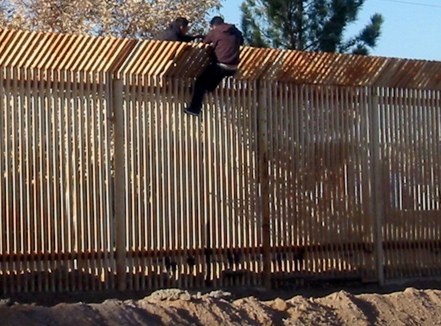 090317-N-5253T-016 DOUGLAS, Ariz. (March 17, 2009) Two men scale the border fence into Mexico a few hundred yards away from where Seabees from Naval Mobile Construction Battalions (NMCB) 133 and NMCB-14 are building a 1,500 foot-long concrete-ined drainage ditch and a 10 foot-high wall to increase security along the U.S. and Mexico border in Douglas, Ariz. (U.S. Navy photo by Steelworker 1st Class Matthew Tyson/Released)